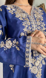 Close-up details of silver floral hand-embroidery and tilla work on the sleeve cuff and bodice of a royal blue raw silk festive dress.
