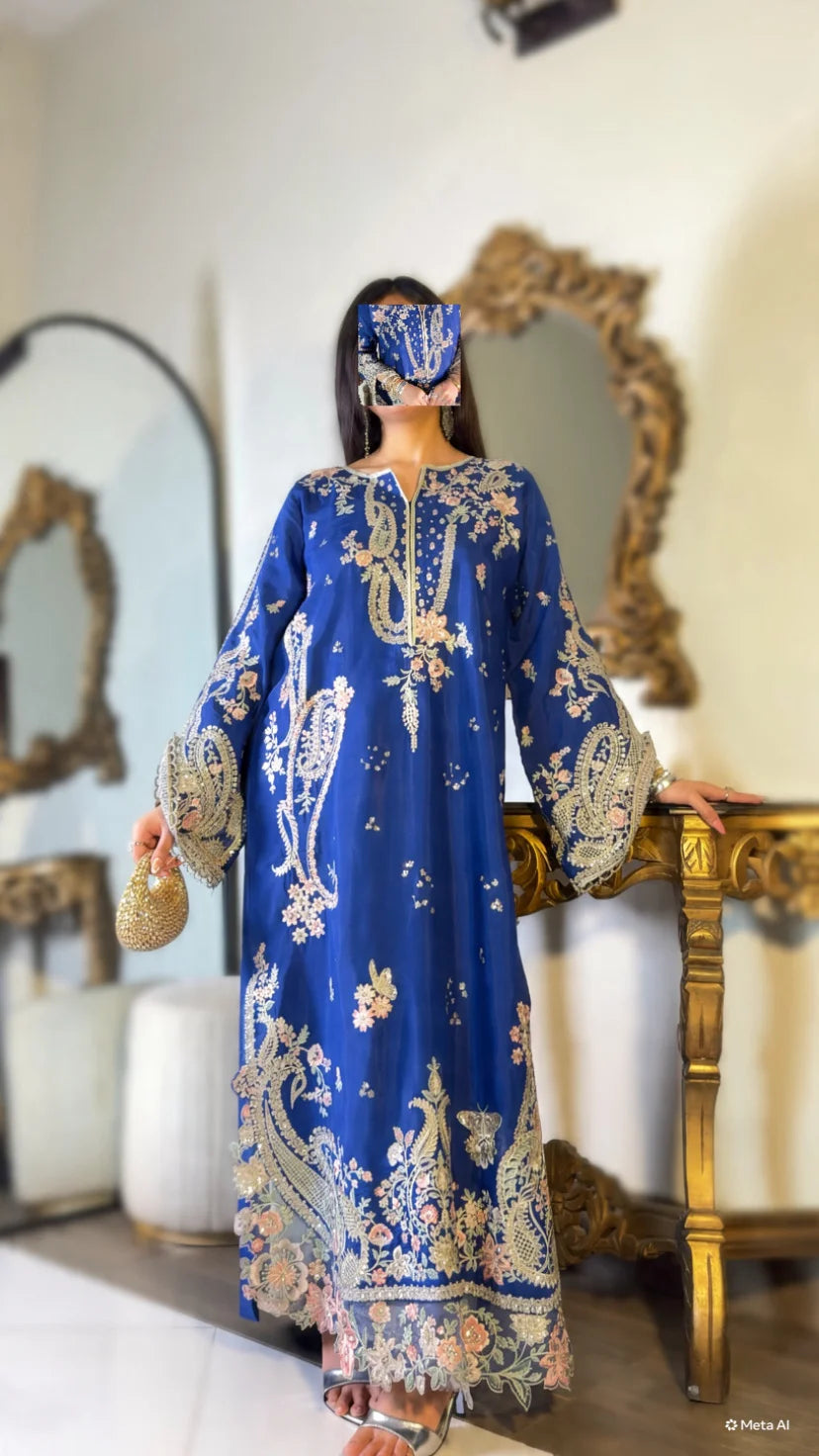 Full-length view of royal blue embroidered kaftan suit with scalloped organza hem, styled with silver heels and gold clutch