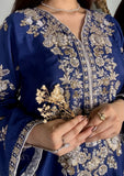 Macro shot of intricate gold and silver tilla handwork, sequins, and kora dabka detailing around the V-neckline of a royal blue luxury pret shirt.
