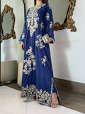 Side profile of a model wearing a luxurious royal blue embroidered raw silk kaftan gown, highlighting the flowing silhouette and tailored fit.