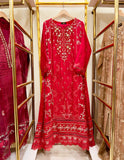 Red embroidered gown dress on a hanger with gold racks and other dresses in the background