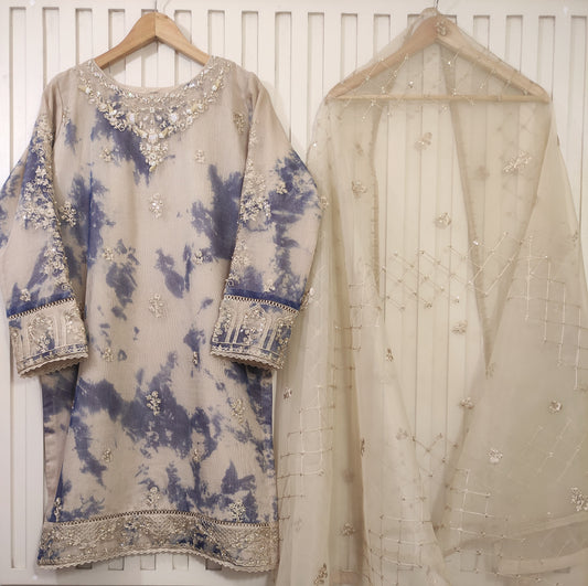 Traditional embroidered outfit with a blue and beige pattern on a white background