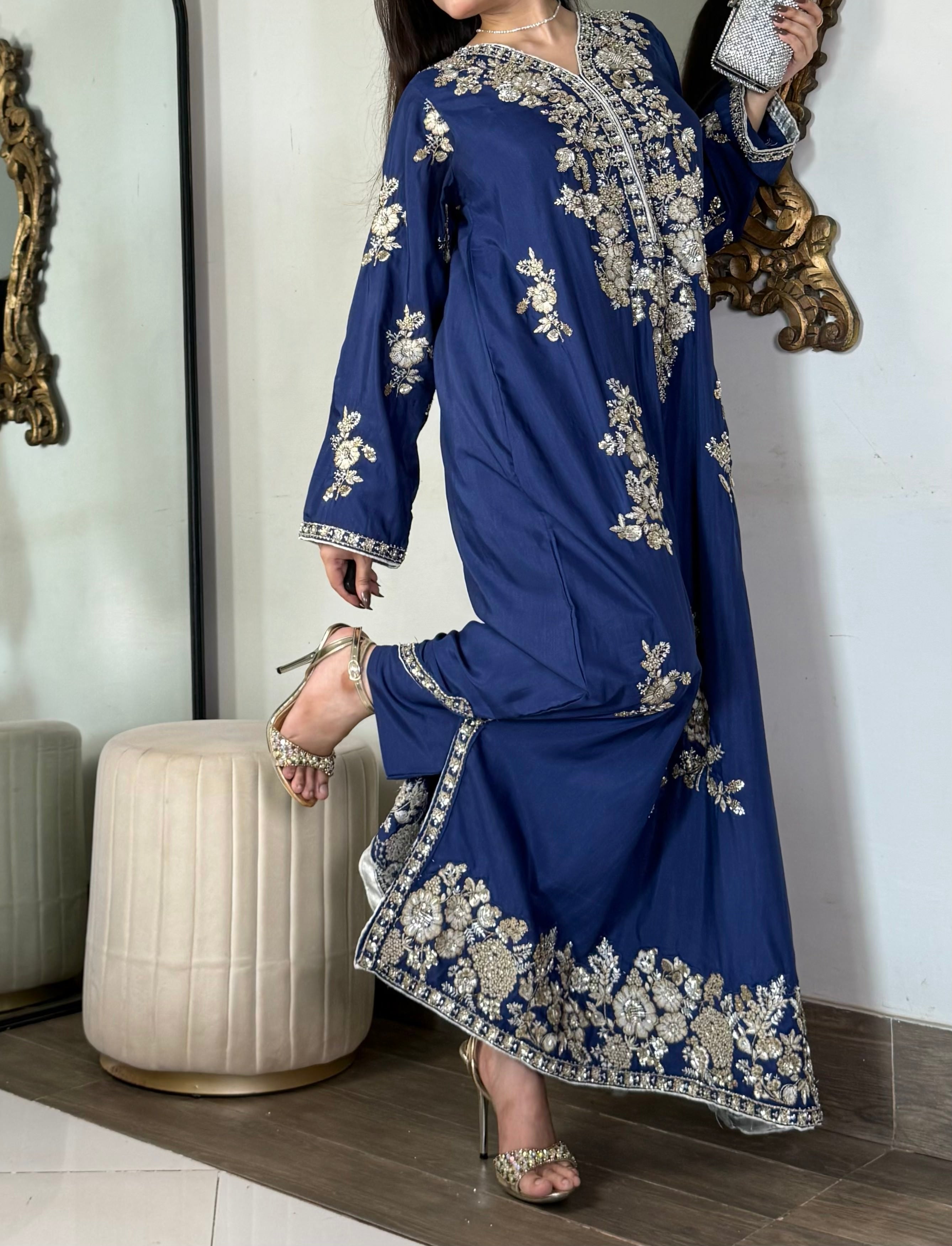 Editorial pose displaying the high side slit detailing, metallic embroidery border, and tailored matching trousers of a royal blue luxury pret outfit.