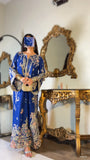 Front view of royal blue embroidered kaftan suit paired with gold clutch bag