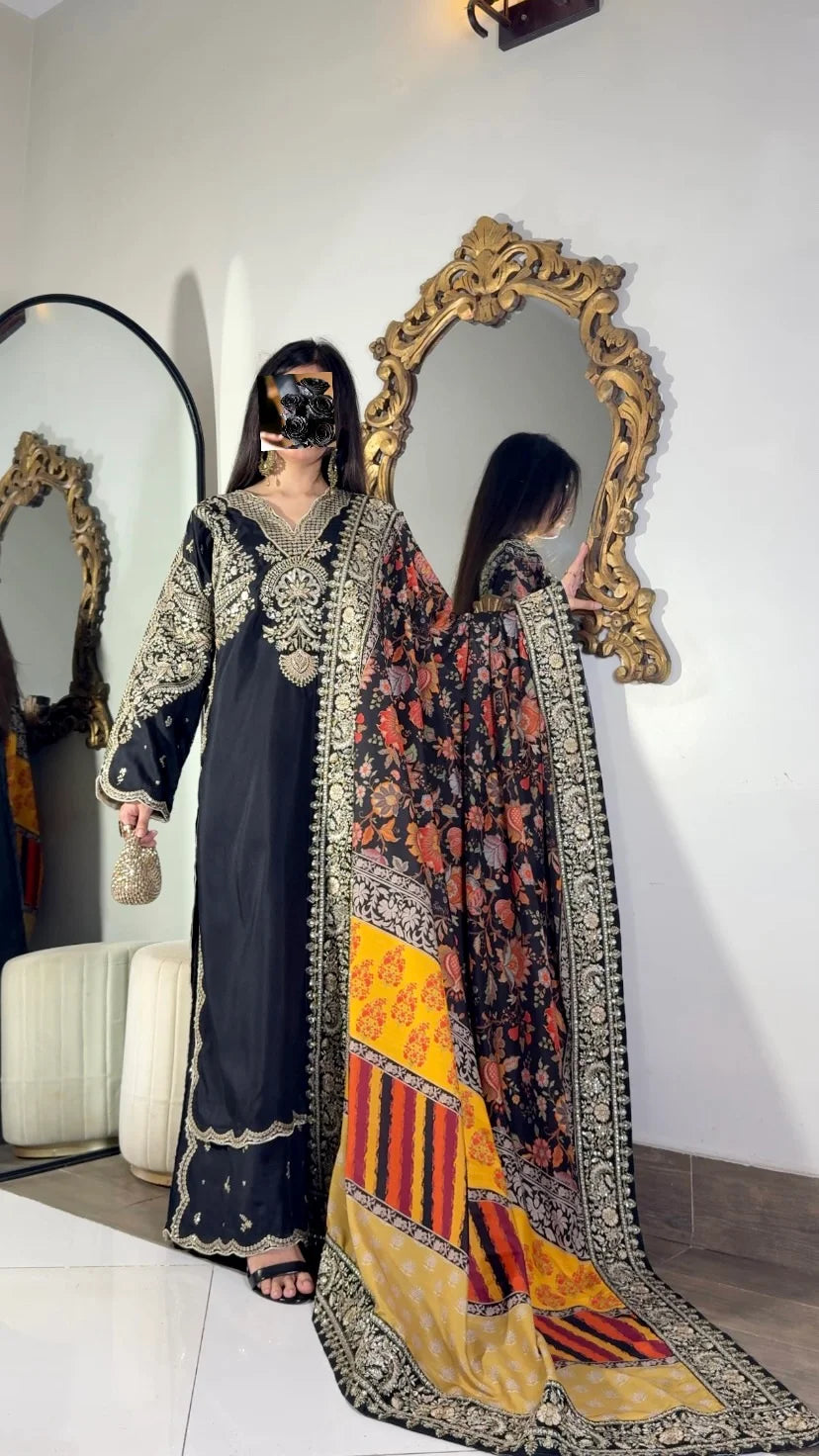 Black and gold embroidered suit with printed silk dupatta draped over shoulder
