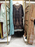 Display of traditional embroidered dresses on hangers in a store.