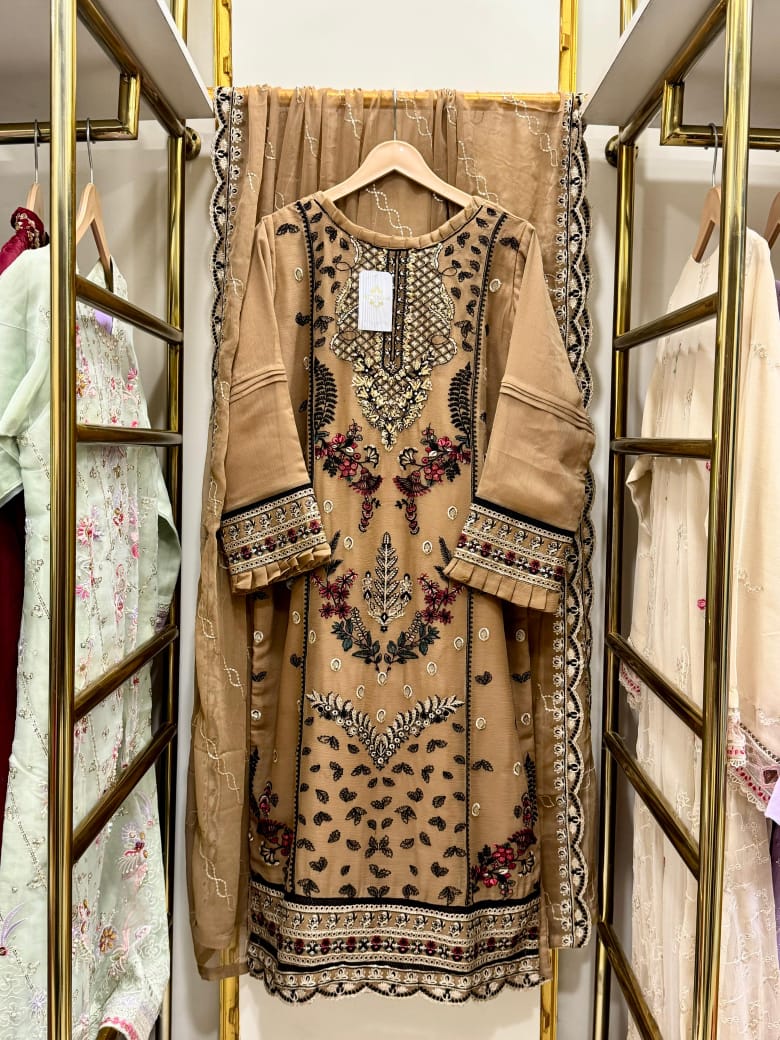 Beige embroidered dress on a hanger in a store setting